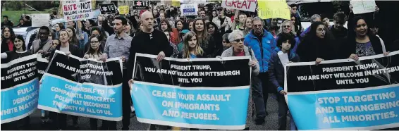  ??  ?? Protesters demonstrat­e near Pittsburgh’s Tree of Life Synagogue Tuesday as U.S. President Donald Trump visited a memorial for the 11 killed in Saturday’s mass shooting.