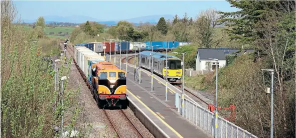  ?? ?? BRIEF ENCOUNTER: GM No. 073, passes Manulla Junction, County Mayo, on April 22 with the 10.05 Ballina to Dublin Port IWT container service. DMU No. 2803+2804 is at the bay platform ready to depart with the 10.39 service to Ballina, after connecting with the 09.45 Westport to Dublin Heuston Intercity service. Finbarr O’Neill