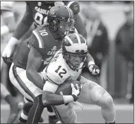  ?? AP/CHRIS O’MEARA ?? Michigan running back Chris Evans (12) is taken down by South Carolina linebacker Skai Moore (10), who had five tackles in the Gamecocks’ 26-19 victory over the Wolverines in the Outback Bowl.