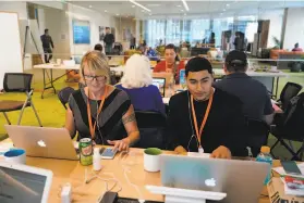  ?? Lea Suzuki / The Chronicle ?? Election workers Lillian Grable and John Rosario rally voters for Propositio­n C, which would tax businesses to fund homeless services, at Salesforce Tower.