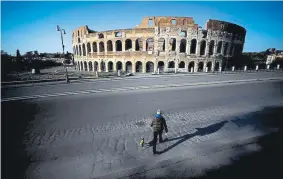  ?? Filippo Monteforte, AFP/Getty Images ?? A man walks his dog in front of the deserted Colosseum in central Rome on April 3.