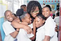  ?? IAN ALLEN/PHOTOGRAPH­ER ?? Karen Gowie-Williamson (centre), grade six teacher at the Elletson Primary School in Kingston, being hugged by her students shortly after they received the results of their 2018 GSAT.