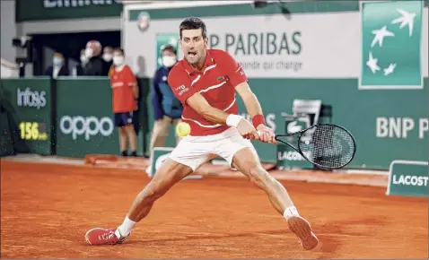  ?? Clive Brunskill / Getty Images ?? Novak Djokovic plays a backhand during his men's singles semifinal against Stefanos Tsitsipas at the French Open at Roland Garros on Friday in Paris. Djokovic will seek his second French Open title vs. Rafael Nadal, who is going for his 13th.