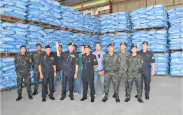  ??  ?? Tan shows part of the smuggled rice seized from the warehouse in Piasau Industrial estate.