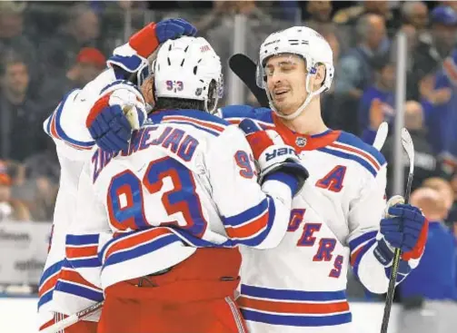  ?? GETTY ?? Mika Zibanejad (c.) and Chris Kreider (r.) celebrate the Rangers’ 4-3 overtime victory over the Islanders at Nassau Coliseum on Tuesday.