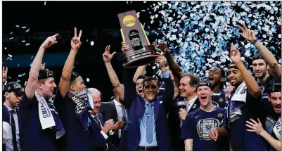  ?? AP/DAVID J. PHILLIP ?? Villanova head Coach Jay Wright (center) holds up the trophy after the Wildcats won their second national championsh­ip in three years with a 79-62 victory over Michigan on Monday night in San Antonio.