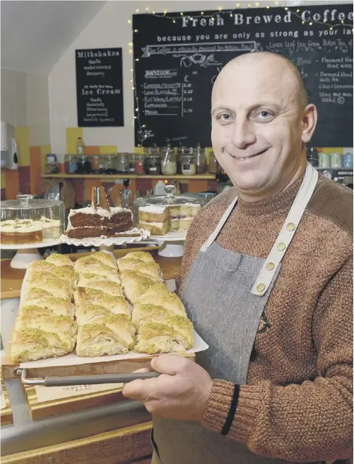  ??  ?? 0 Nour Taleb, a refugee from near Aleppo, with some of his Syrian pastries which are going down a storm in Haddington