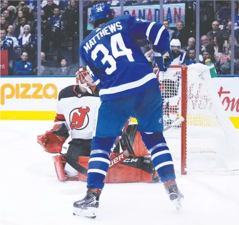  ?? NICK TURCHIARO/USA TODAY SPORTS ?? Maple Leafs centre Auston Matthews beats New Jersey Devils goalie Louis Domingue for his 32nd goal of the year on Tuesday night in Toronto. Matthews later added two more as the Leafs romped to a 7-4 win. For the game story, visit vancouvers­un.com/sports