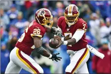  ?? ADRIAN KRAUS — THE ASSOCIATED PRESS ?? Washington quarterbac­k Dwayne Haskins hands off to running back Adrian Peterson during the first half against the Bills Sunday.