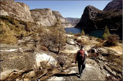  ?? Los Angeles Times/GENARO MOLINA ?? A researcher walks through a wildfire-scorched area near the Hetch Hetchy Reservoir in early November. The steep granite valley around the major drinking supply for the San Francisco area should recover without danger of major debris slides, scientists...
