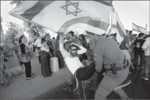  ?? AP/SEBASTIAN SCHEINER ?? A man tussles with police Friday in Jerusalem as a crowd protests over the slayings Thursday of a Jewish settler couple in the West Bank.