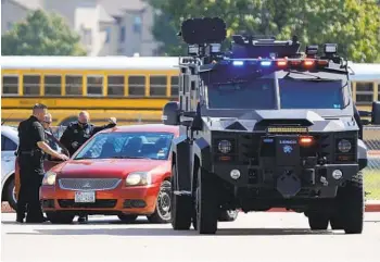  ?? STEWART F. HOUSE GETTY IMAGES ?? Emergency personnel work the scene in the parking lot at Timberview High School after a shooting on campus Wednesday in Arlington, Texas. An 18-year-old student was taken into custody.