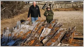  ?? (AP/Newsday/Steve Pfost) ?? Tony Femminella, executive director of the Fire Island Lighthouse Preservati­on Society, and Betsy DeMaria, museum technician with Fire Island National Seashore, stand Jan. 27 beside a section of the hull of a ship believed to be the SS Savannah at the Fire Island Lighthouse in New York.