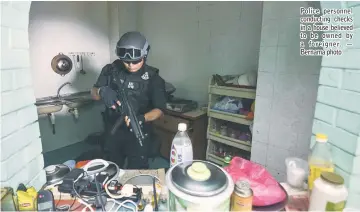  ??  ?? Police personnel conducting checks in a house believed to be owned by a foreigner. — Bernama photo