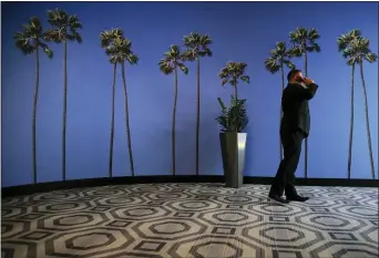  ?? JAE C. HONG — THE ASSOCIATED PRESS FILE ?? In this file photo a man talks on the phone in a hallway adorned with the palm treeprinte­d wallpaper at a hotel near the Los Angeles Internatio­nal Airport in Los Angeles. The Senate has passed a bill that cracks down on robocalls, a persistent and costly problem for Americans. The bill has already passed the House and now goes to President Donald Trump for his signature.