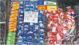  ??  ?? SIM CARDS are laid out at a loading station for local telecommun­ications companies at a store along a sidewalk in Metro Manila, Nov. 21.
