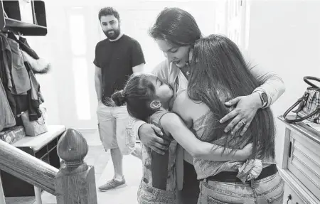 ?? Kin Man Hui / Staff file photo ?? Travel nurse Teresa Beard hugs her daughters at their San Antonio home in 2020 after an eight-week job in New York.