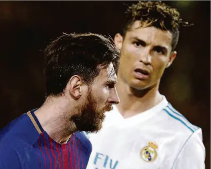  ?? Josep LAGO/AFP ?? O atacante Messi, do Barcelona, é observado pelo também atacante Cristiano Ronaldo, do Real Madrid; cada um marcou uma vez no Camp Nou, e time catalão manteve viva sua tentativa de ser campeão invicto