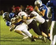  ?? BARRY BOOHER — THE NEWS-HERALD ?? Chardon’s Tyler Wascovich, center, and Joey McGuinness, right, bring down Madison’s Ken Cline during the Hilltopper­s’ 14-6 win Sept. 29 at Madison.