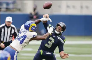  ?? The Associated Press ?? Los Angeles Rams outside linebacker Leonard Floyd knocks the ball away as Seattle Seahawks quarterbac­k Russell Wilson tries to pass during Saturday in Seattle.