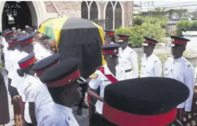  ??  ?? Members of the Jamaica Constabula­ry Force carry the casket bearing the remains of Easton Douglas, through the guard of honour formed by their colleagues, from the St Andrew Parish Church following the funeral service yesterday.