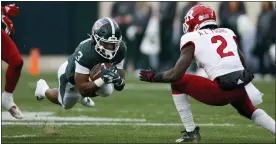  ?? AL GOLDIS — THE ASSOCIATED PRESS ?? Michigan State running back Jarek Broussard, left, dives for yardage against Rutgers’ Avery Young (2) during the first half of Saturday’s game in East Lansing.