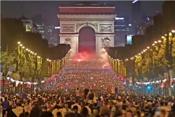  ?? — AFP ?? French fans celebrate their team’s victory over Belgium in front of The Arc de Triomphe on the Champs Elysees in Paris.