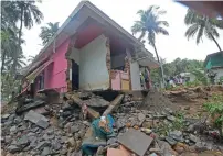  ?? AFP ?? residents look at a partially destroyed house after heavy rains led to a landslide in Kannappank­und, Kerala, on Saturday. —