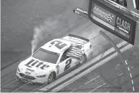  ?? Phelan M. Ebenhack/The Associated Press ?? ■ Brad Keselowski (2) carries a United States flag past the finish line Sunday after winning the NASCAR Clash auto race at Daytona Internatio­nal Speedway in Daytona Beach, Fla.