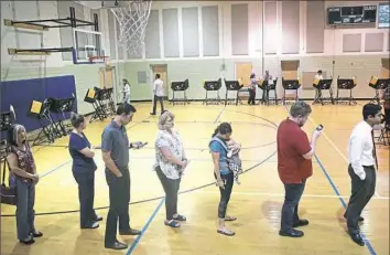  ??  ?? Voters in Ohio’s 12th Congressio­nal District wait in line to cast a ballot for their next congressma­n on Tuesday in Columbus, Ohio.