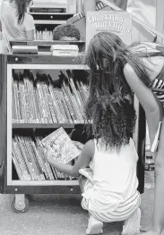 ?? Steve Gonzales / Staff photograph­er ?? Second Ward children check out the bookmobile since their branch library remains closed.