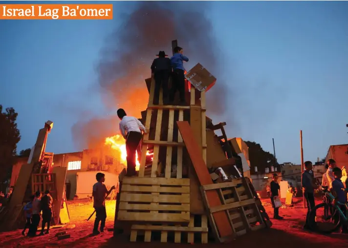  ??  ?? Ultra-Orthodox Jews light a bonfire during the Jewish holiday of Lag Ba'Omer celebratio­n in Bnei Brak, Israel on Thursday. The holiday marking the end of a plague said to have decimated Jews during the Roman times. Photo: AP