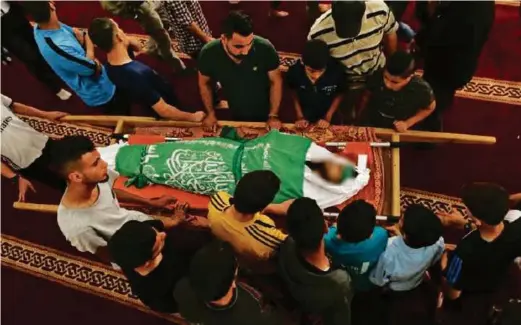  ?? AFP PIC ?? Palestinia­n mourners surround the body of Yazan al-Tubasi, killed during clashes in Gaza.