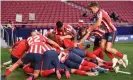  ??  ?? Luis Suárez is mobbed by his teammates after scoring Atlético’s 88th-minute winner against Osasuna last Sunday. Photograph: Denis Doyle/Getty Images