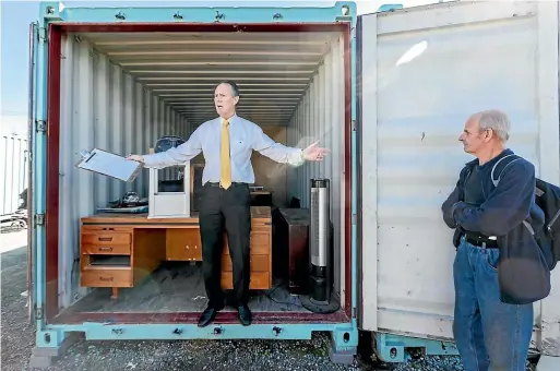  ?? VIRGINIA WOOLF/STUFF ?? Auctioneer John Walker finds storage auctions a little sad, but he admitted the chance to find buried treasure was exciting. Auction winner Wayne Robinson looks on while Walker gets the bidding started.