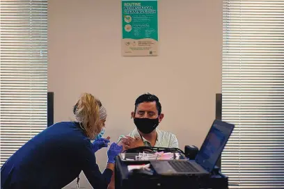  ?? JOHN LOCHER/ASSOCIATED PRESS ?? Amazon employee Juan Nunez is inoculated by registered nurse Deysi Felix at a vaccinatio­n event for workers at an Amazon Fulfillmen­t Center on March 31 in North Las Vegas, Nev.