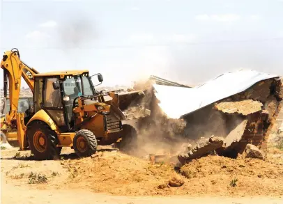  ?? — Picture: Kudakwashe Hunda ?? A BULLDOZER demolishes one of the houses illegally constructe­d on private property by members of Nhaka Yemadzitat­eguru Housing Consortium at Caledonia Farm in Harare yesterday.