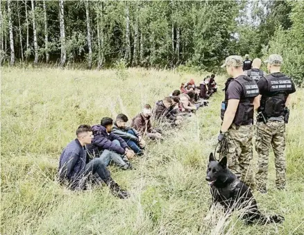  ?? POLISH BORDER PATROL / REUTERS ?? Guàrdies de frontera polonesos custodiant migrants que han creuat des de Bielorússi­a, dilluns passat