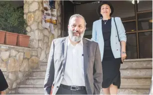  ?? (Yonatan Sindel/Flash90) ?? INTERIOR MINISTER Arye Deri and his wife, Yaffa, leave their home in Jerusalem yesterday morning on their way to the Lahav 433 National Crime Unit.