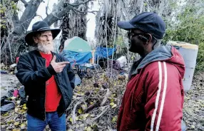  ??  ?? Above: Gary Wayne (left), a homeless Army veteran, talks with Felton Mackey, outreach coordinato­r with Shelter Inc., about the services the agency offers vets.