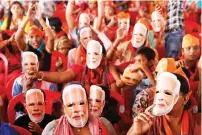  ?? — REUTERS ?? Supporters of India’s Prime Minister Narendra Modi wear masks of his face, as they attend an election campaign rally in Meerut.