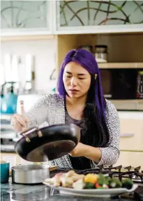  ??  ?? RIGHT: MingCheau whips up lunch in her light and airy, minimalist kitchen.