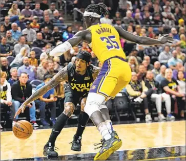  ?? Rick Bowmer Associated Press ?? JAZZ GUARD Jordan Clarkson drives as Wenyen Gabriel defends during Utah’s 139-116 win over an overmatche­d Lakers squad. Gabriel was part of an adjusted lineup that produced offense but faltered defensivel­y.