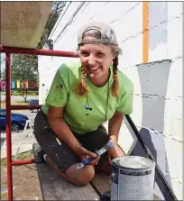  ??  ?? Wendy Popko is shown taking a break while working on a mural for the Sterling Heights Children’s Garden.