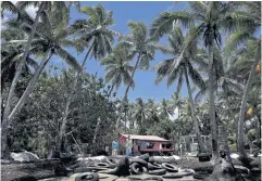  ?? AFP ?? Lavenia McGoon stands on a makeshift seawall outside her beachfront house in Togoru, outside Fiji’s capital Suva.