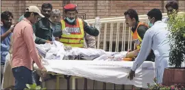  ??  ?? A Pakistani rescue worker and hospital staff transport a victim of an oil tanker explosion at a hospital in Multan, Pakistan on Sunday . Dozens of people are critically injured.