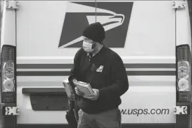  ?? ASSOCIATED PRESS ?? POSTAL CARRIER JOSIAH MORSE HEADS OUT to deliver mail and packages, Wednesday in Portland, Maine. The U.S. Postal Service’s stretch of challenges didn’t end with the November general election and tens of millions of mail-in votes. The pandemic-depleted workforce fell further into a hole during the holiday rush, leading to long hours and a mountain of delayed mail.