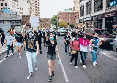  ?? KASSI JACKSON PHOTOS/HARTFORD COURANT ?? Protesters march together through downtown Hartford on Saturday during a Black Lives Matter and“Justice for Breonna Taylor”rally.