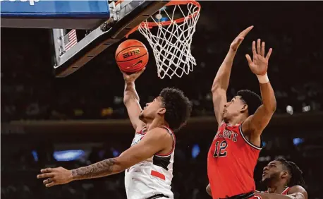  ?? Mary Altaffer/Associated Press ?? UConn forward Jaylin Stewart, left, goes to the basket past St. John’s guard RJ Luis Jr. during the first half of the Big East semifinals Friday in New York.