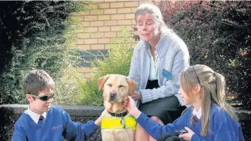  ??  ?? ●●Whitworth High School pupils Daniel Burton and Ruby Taylor with “William” and her owner Toni Forrest